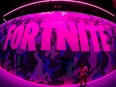 An attendee stops to text next to Epic Games Fortnite sign at E3, the annual video games expo revealing the latest in gaming software and hardware in Los Angeles, Calif., June 12, 2019.