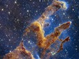 This handout photo provided by NASA on October 19, 2022 shows the Pillars of Creation that are set off in a kaleidoscope of color in NASAs James Webb Space Telescopes near-infrared-light view. - The pillars look like arches and spires rising out of a desert landscape, but are filled with semi-transparent gas and dust, and ever changing. This is a region where young stars are forming  or have barely burst from their dusty cocoons as they continue to form.