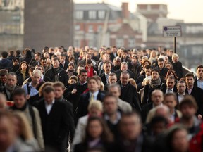 City workers walk across London Bridge on their commute to the U.K. capital's financial district. Seventy companies signed up to the UK trial of the four-day week. Results will come out in February.