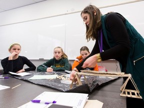 Structural engineer Sandra Renihan helps schoolgirls with the bridge they built, at the 2018 CHOICES conference in Edmonton.