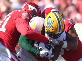 Edmonton Elks running back James Wilder Jr. is tackled by Calgary Stampeders defenders at McMahon Stadium in Calgary on Saturday, June 25, 2022.