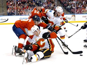 Calgary Flames center Dillon Duve (29) and Florida Panthers defenseman Mackenzie Wieger (52) battle it out for the loose pack in the first period at the BB&T Center.