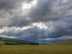 The sun finds its way through a gap in the clouds over the Willow Creek valley in the Porcupine Hills west of Nanton, Alta., on Tuesday, August 23, 2022.