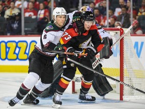 Calgary Flames forward Tyler Toffoli battles Arizona Coyotes defenceman Jakob Chychrun at Scotiabank Saddledome in Calgary on Monday, Dec. 5, 2022.