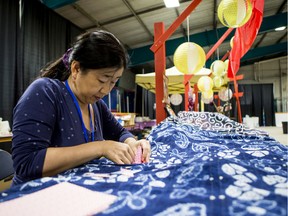 Asami Zimmer folds paper cranes at the Japan Pavilion at Folk Fest.