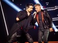 Kevin Richardson and Nick Carter are pictured onstage during Backstreet Boys' DNA World Tour in 2019.