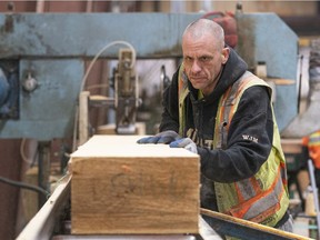 A mill worker moved a piece of wood after being fed through a cutting machine at the PowerWood mill in Agassiz.