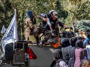 Members of the Taliban security forces arrive as Afghan women march during a demonstration they call Stop Hazara Genocide. Dozens of women from Afghanistan’s minority Hazara community protested in the capital Oct. 1, after a suicide bombing a day earlier killed 20 people at a private school.
