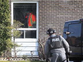 A police officer attempts to contact a man inside his home on Block 1300 of Copperfield Place in the Little River Acres area of Windsor on December 1, 2022.