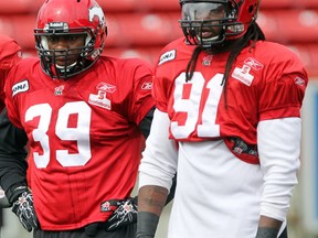 Stamps defensive lineman Charleston Hughes, left, and Kevin Dixon