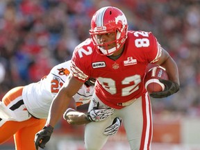 Calgary Stampeders Nik Lewis (right) tries to evade BC Lions Ryan Phillips during their game at McMahon Stadium