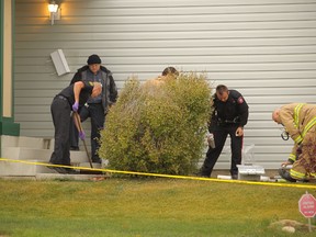 Firefighters and police officers clean up in the aftermath of a fatal shooting at a home on Citadel Peak Circle N.W. Officers shot Peter Spiewak, 32, when he came to the door with an axe. He died at the scene.