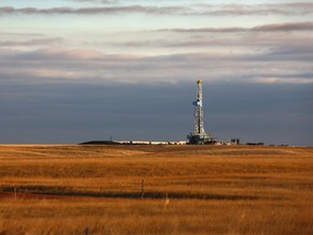 A drilling rig works as a pump jack in the foreground pulls oil from the Bakken formation in North Dakota.                                           Matthew Staver/Bloomberg