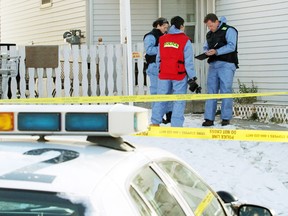 Investigators examine a home in the 3600 block of 39th Street N.E. Officers responding to a 911 call Friday found a woman dead inside. The woman's common-law spouse has been charged with second-degree murder.