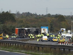 Rescue workers gather around the scene of an accident which occured on the M5 motorway near Taunton in Somerset, on November 5, 2011. At least 7 people have been killed and around 51 injured after a collision involving 34 vehicles sparked explosions and an inferno. (Carl Court, Getty Images)