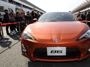Journalists check out Toyota Motors'  production prototype of the "86" compact rear-wheel-drive sports car during its press preview at the Toyota Gazoo Racing Festival at the Fuji Speedway, Japan, on November 27, 2011. (Toshifumi Kitamura, Getty Images)