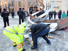 Workers remove the sculpture left by the Occupy Calgary protesters on Dec. 12.