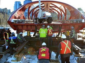 Construction workers and engineers use large hydraulic jacks to slowly lower the Peace Bridge in Calgary  into position on Dec. 6 (Gavin Young/Herald)