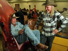 Sheldon Smithens and Scott Cozens from the TV show The Canadian Pickers goof around with one of their finds, a rocketship ride, at the Hillhurst Sunnyside Community Association in Calgary, December 10, 2011.