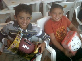 Youngsters in Akumal, Mexico, show off the gifts they received in a Christmas Eve celebration that CFL players helped support.