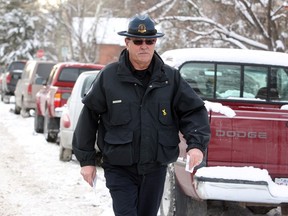 Neal Bynkoski, officer for Calgary Parking Authority, gives warnings to vechicles on a snow route street on Dec. 5.(Christina Ryan/Herald)