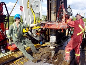 Roughnecks work on the drilling floor of Precision Drilling rig # 521.