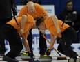 Ben Hebert, left, and Marc Kennedy scrub a rock with Kevin Martin urging them on. Photo, Michael Burns Jr., Canadian Curling Association