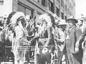 During his visit to Calgary, as head of the British Empire Service League in 1925, Earl Haig attended the Stampede and took part in the general fun. Here he is being given a name and native head dress by Big Plume, chief of the Sarcee band. L-R: Big Plume; Long Lance; Earl Haig, shaking hands; Cappy Smart; E. L. Richardson, fair manager; Doctor Tom Murray, Indian agent and medical officer of the Sarcee. Courtesy Glenbow Archives.  NB-16-121