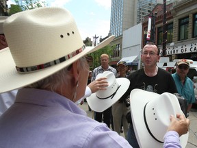Stampede volunteers gave away about 9,000 cowboy hats on Stephen Avenue Mall in 2009  as part of the Head in the Hat promotion. Stampede volunteer Heather Rasmussen hands out some of the hats.
Photo: Herald archives