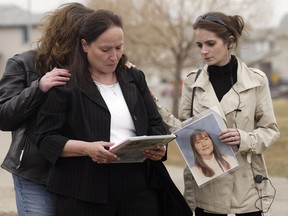 Sue Martin, mother Terrie Ann Dauphinais, is comforted by her niece Kristin Boutot, right, and her friend, Caroline Stewart, left, during a vigil for her daughter near the scene on Citadel Peak Circle N.W. in 2008.