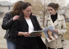 Sue Martin, mother Terrie Ann Dauphinais, is comforted by her niece Kristin Boutot, right, and her friend, Caroline Stewart, left, during a vigil for her daughter near the scene on Citadel Peak Circle N.W. in 2008.