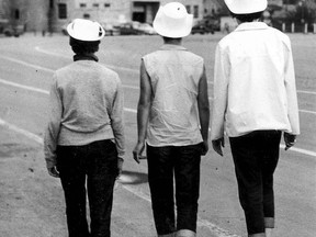 Three girls in white hats and rolled-up blue jeans stroll the Stampede grounds in 1956. 
Photo: Herald archives