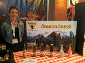 Carly Felton of The Grizzly Paw Brewing Company displays the variety of sodas the company produces, shown here in front of a photo of the company’s soon-to-be-opened brewery in Canmore. Monica Zurowski photos.