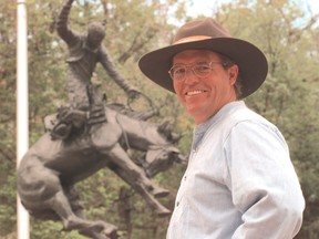 Artist Rich Roenisch in front of his bronze sculpture,"Bronc Twister" on the Stampede Grounds. Herald Archives