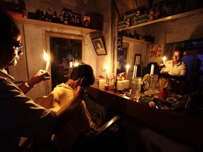 A barber continues to ply his trade in India despite a massive blackout which plunged half the nation into darkness Tuesday.