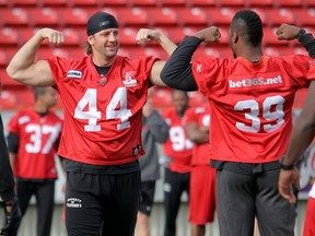 Stamps' defensive ends Justin Phillips, left, and Charleston Hughes compare muscles during a 2011 practice. Photo, Stuart Gradon, Calgary Herald