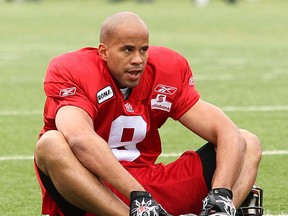 Stamps running back Jon Cornish works on his बद्धकोणसन (also known as the Baddha Konasana) yoga pose prior to a practice during training camp.