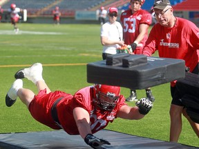 Offensive lineman Spencer Wilson, who'll start his first game on Thursday, goes through a drill with O-line coach Mike Gibson during practice on Tuesday. Photo, Ted Rhodes, Calgary Herald