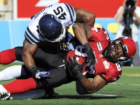 Argos linebacker (and former Stampeder) Robert McCune makes the tackle on Stamps slotback Nik Lewis during the Argos' win in Calgary on Saturday. Photo, Larry MacDougal, Canadian Press