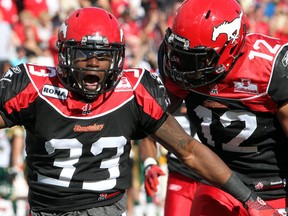 Stamps linebacker Chris Randle, left, celebrates his second-half interception with teammate Juwan Simpson during Monday's Stampeder victory over Edmonton. Photo, Lorraine Hjalte, Calgary Herald