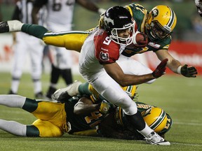 Stamps running back Jon Cornish breaks away from a couple of Edmonton tacklers during Calgary's 20-18 win over the Eskimos on Friday night. Photo, Greg Southam, Edmonton Journal