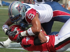 Former Alouettes defensive end Anwar Stewart makes a tackle on Calgary receiver Romby Bryant during a 2011 game at McMahon Stadium. Photo, Christina Ryan, Calgary Herald