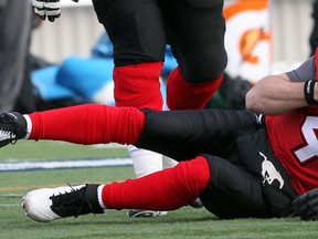Stamps quarterback Drew Tate lays on the ground after taking the helmet-to-helmet hit from Riders defensive lineman Tearrius George on Sunday. Photo, Lorraine Hjalte, Calgary Herald