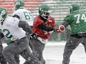 Riders quarterback Darian Durant hands off the ball during a snowy day in Regina on Thursday. Photo, Don Healy, Regina Leader-Post