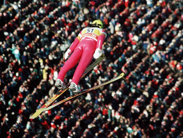Horst Bulau soars in the 90m ski jump, after days of event delay.