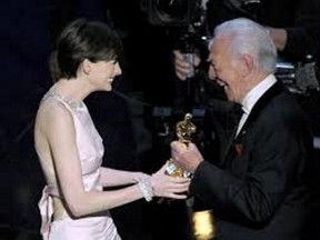 Anne Hathaway accepts the Best Actress Oscar from Christopher Plummer.