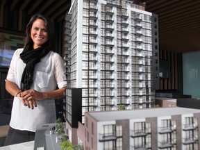 Sales Manager at FIRST, Katy Tansley, stands recently next to the model of the new condos being built at East Village in Calgary.