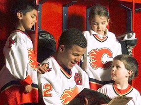 Flames star Jarome Iginla reads a story in the dressing room, much to the delight of young readers. (Note: perhaps this 2003 photo was staged, a bit)