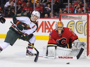 Zach Parise #11 of the Minnesota Wild grimaces as he eyes the loose puck in front of Joey MacDonald #35 of the Calgary Flames during an NHL game at Scotiabank Saddledome on April 15, 2013 in Calgary, Alberta, Canada. (Derek Leung/Getty Images)