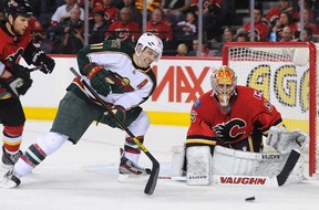 Zach Parise #11 of the Minnesota Wild grimaces as he eyes the loose puck in front of Joey MacDonald #35 of the Calgary Flames during an NHL game at Scotiabank Saddledome on April 15, 2013 in Calgary, Alberta, Canada. (Derek Leung/Getty Images)